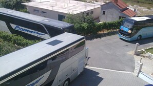 Un espace de stationnement où se trouvent deux autobus, dont l’un est identifié par l’inscription « BomaBus » et l’autre arbore une livrée bleue et blanche.