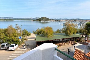 Un puerto deportivo con barcos, una zona de estar cubierta y un cartel de estacionamiento.