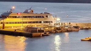 Un ferry llamado 'JADROLINIJA' atracado en un muelle, con gente embarcando y desembarcando.