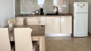 Eine moderne Küche mit Holzarbeitsplatte, Spüle, Kaffeemaschine und einem weißen Kühlschrank.