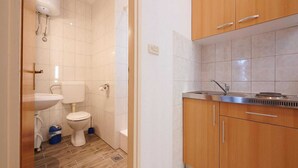 Une petite salle de bain comprenant des toilettes, un lavabo et une douche.