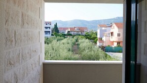 A balcony with a view of residential buildings and greenery.