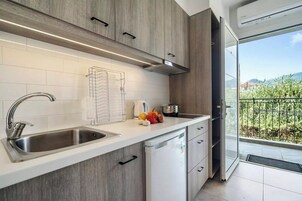 Suite junior, vistas a la piscina | Cocina privada | Frigorífico, hervidor eléctrico y trona infantil