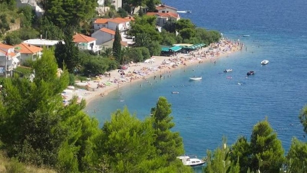 Une ville côtière avec une plage, des bateaux et des bâtiments.