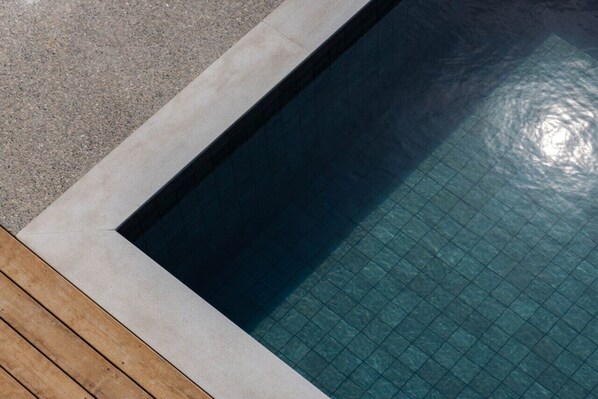 A rectangular swimming pool with a tiled interior and a wooden deck surrounding it. - Luxurious Townhouse with private Pool in Paphos (Chlorakas)