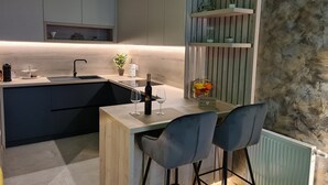 A modern kitchen with a wooden island, bar stools, and a built-in wine rack. - Wellness Apartments - Studio Apartment with Terrace (G3) (Varazdin)
