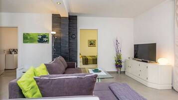 A modern living room with a sofa, a television, and a cabinet.