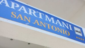 Un edificio de apartamentos con un letrero que dice "APARTMANI SAN ANTONIO" y una escalera que conduce a la entrada.