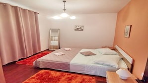 Un dormitorio con dos camas, ventilador de techo, mesita de noche con lámpara y un espejo.