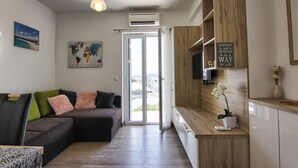 Una sala de estar moderna con un sofá, un televisor de pantalla plana y un mueble de madera.