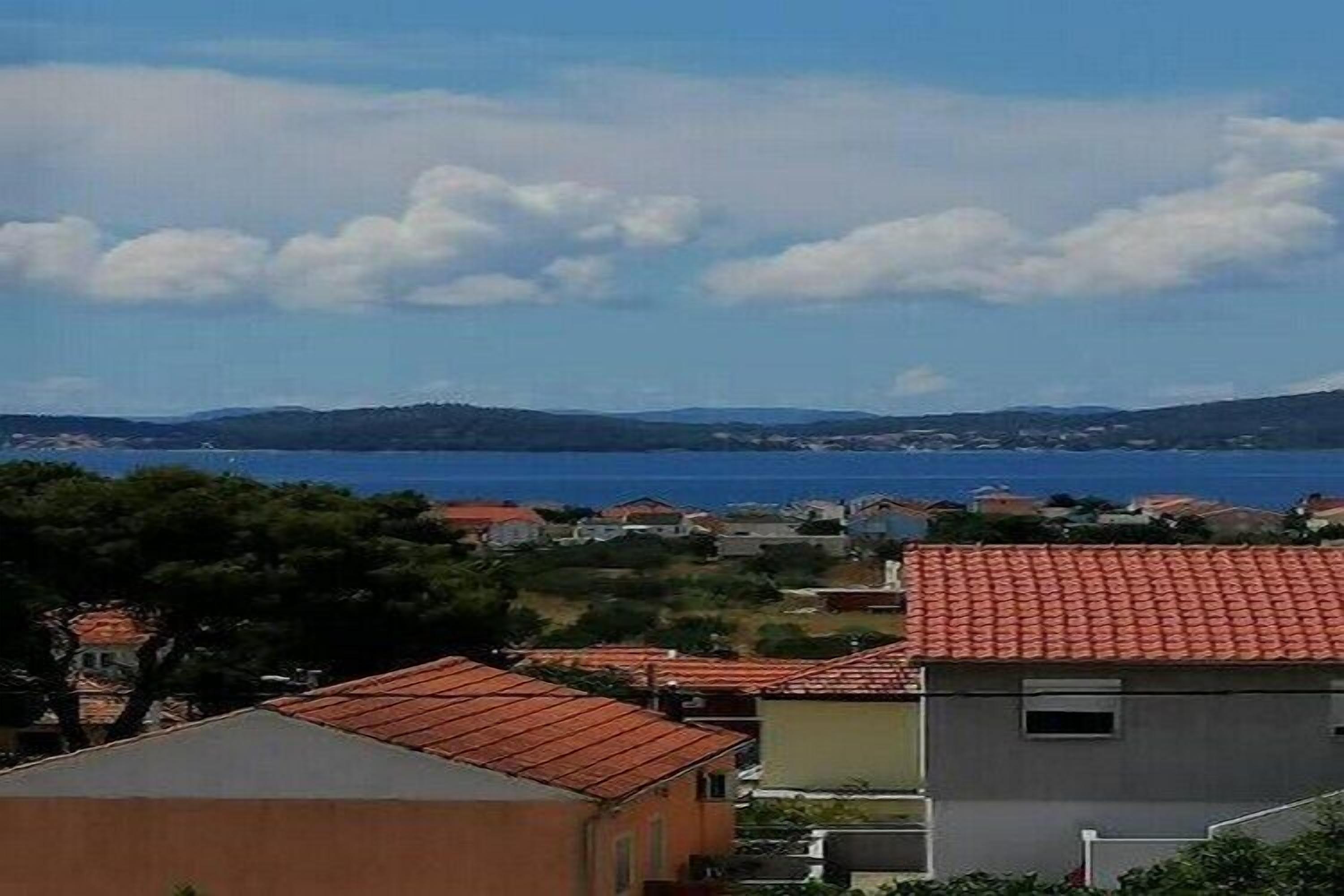 Une ville côtière avec des bâtiments, un ciel dégagé et une vue sur la mer.