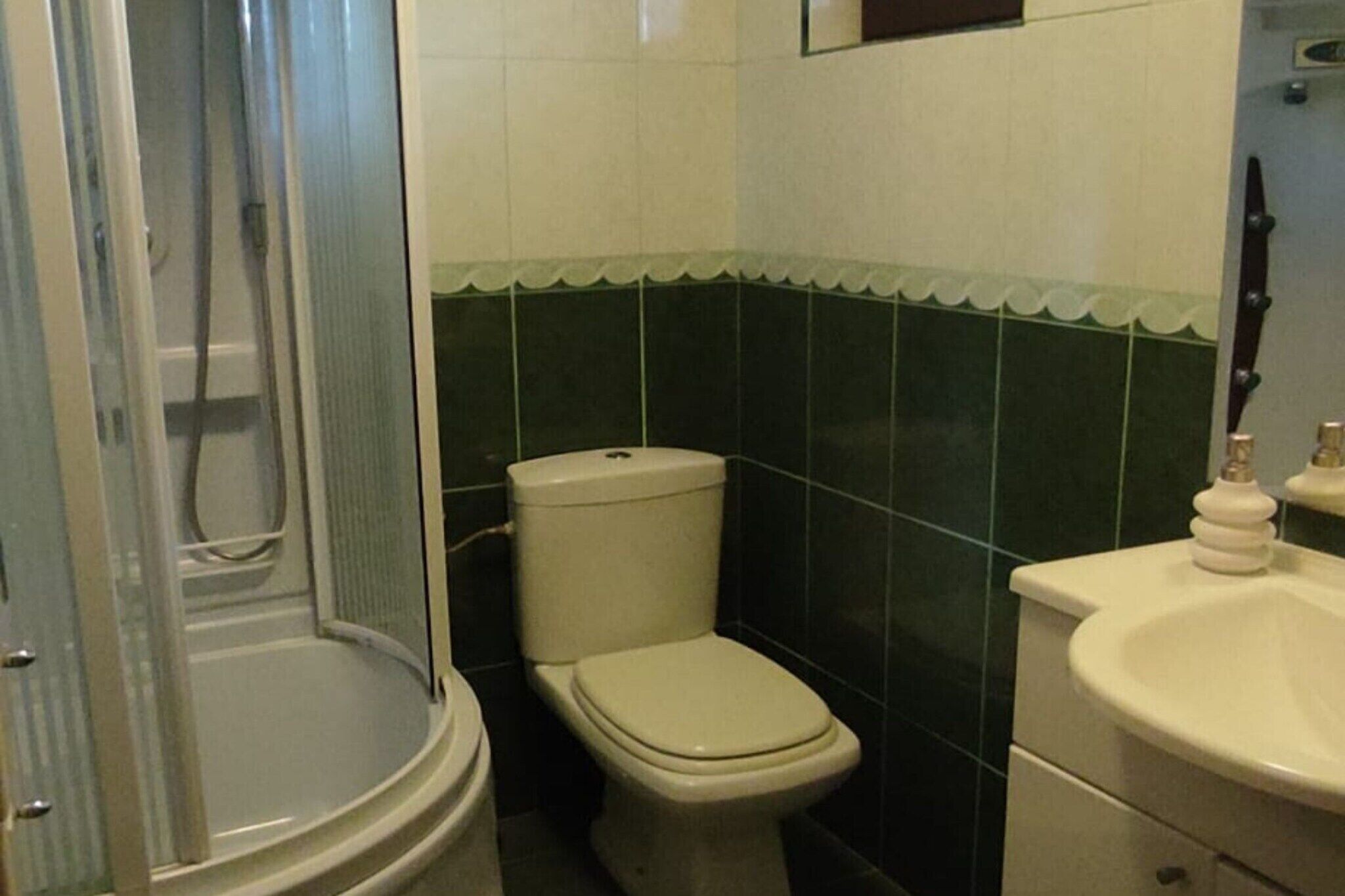 A bathroom with a shower, toilet, and sink.