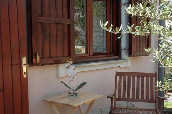 A wooden door with a window, a small table with a plant, and a wooden chair. - Apartments Smilje i Maslina - One Bedroom Apartment with Terrace 2 (Karin Gornji)
