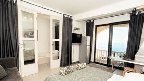 A modern hotel room with a balcony, a bed, a TV, and a minibar. - Apartments & Room Vesna - Superior Studio Apartment with Sea View (Brela)