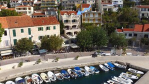 A marina with numerous small boats docked, surrounded by residential buildings with red-tiled roofs and balconies. - Apartments & Room Vesna - Superior Studio Apartment with Terrace and Sea View (Brela)