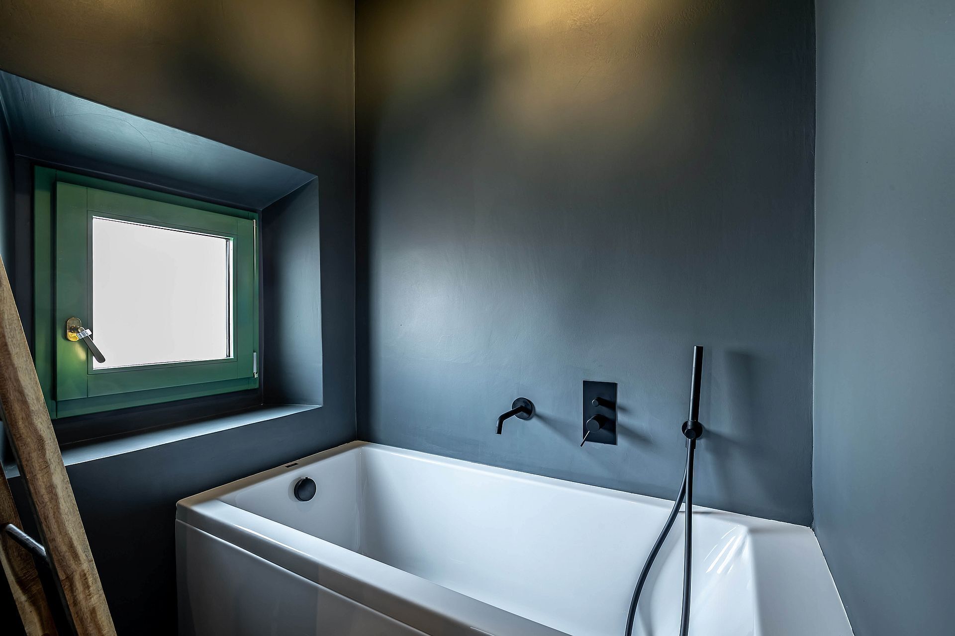Une salle de bain avec une baignoire, une fenêtre et une douche.