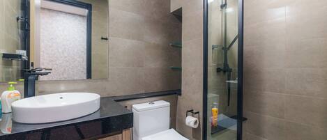 A modern bathroom with a sink, toilet, and glass-enclosed shower.