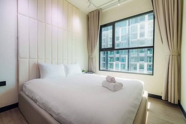 A modern hotel room with a large bed, a window with curtains, and a city view. - Imperial De La SoL District 4 (Ho Chi Minh City)