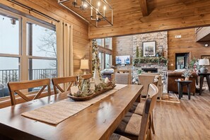 Un intérieur en bois comprenant une table à manger, des chaises, une cheminée et un mur en pierre.