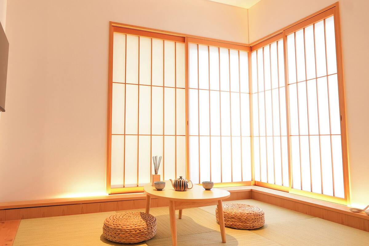 A traditional Japanese room with tatami flooring, a low wooden table, and shoji screens.