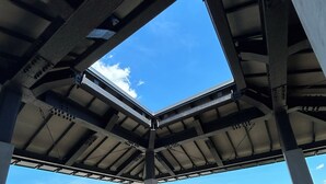 Una terraza en la azotea con vistas despejadas al cielo y edificios lejanos.