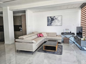 Departamento Confort, vista al mar | Área de sala de estar | Televisión de pantalla plana