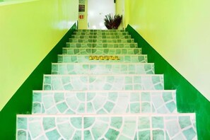 A staircase with a green wall and patterned floor tiles. - RedDoorz @ D128 Lodge Cagayan Valley (Tuguegarao)