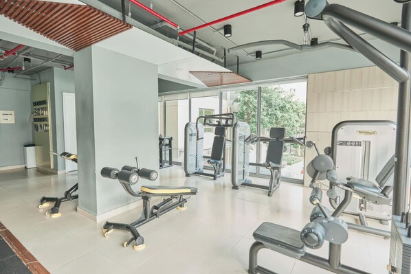 Una palestra moderna con diverse macchine per esercizi, ampie finestre e un ambiente pulito e spazioso.