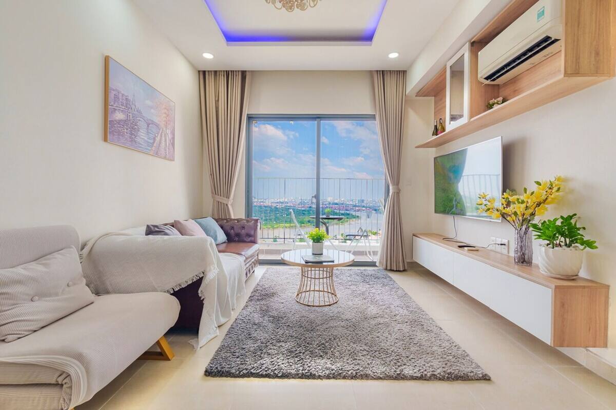 A modern living room with a sofa, a coffee table, and a TV on a wall.