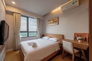 A hotel room with a bed, a desk, a chair, a TV, and a window with curtains. - Genius Saigon - Masteri Thao Dien District 2 (Ho Chi Minh City)