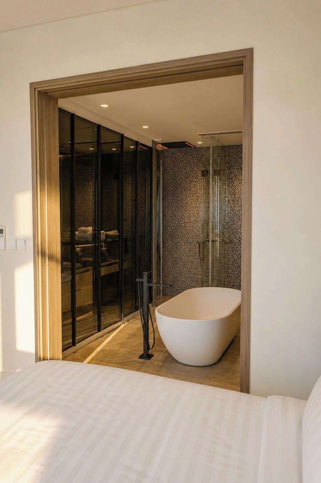 A modern bathroom with a freestanding bathtub, a glass shower enclosure, and a visible bathroom counter.