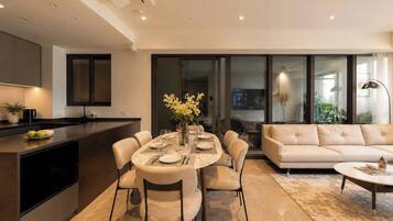 A modern living space with a dining area, kitchen, and seating area.