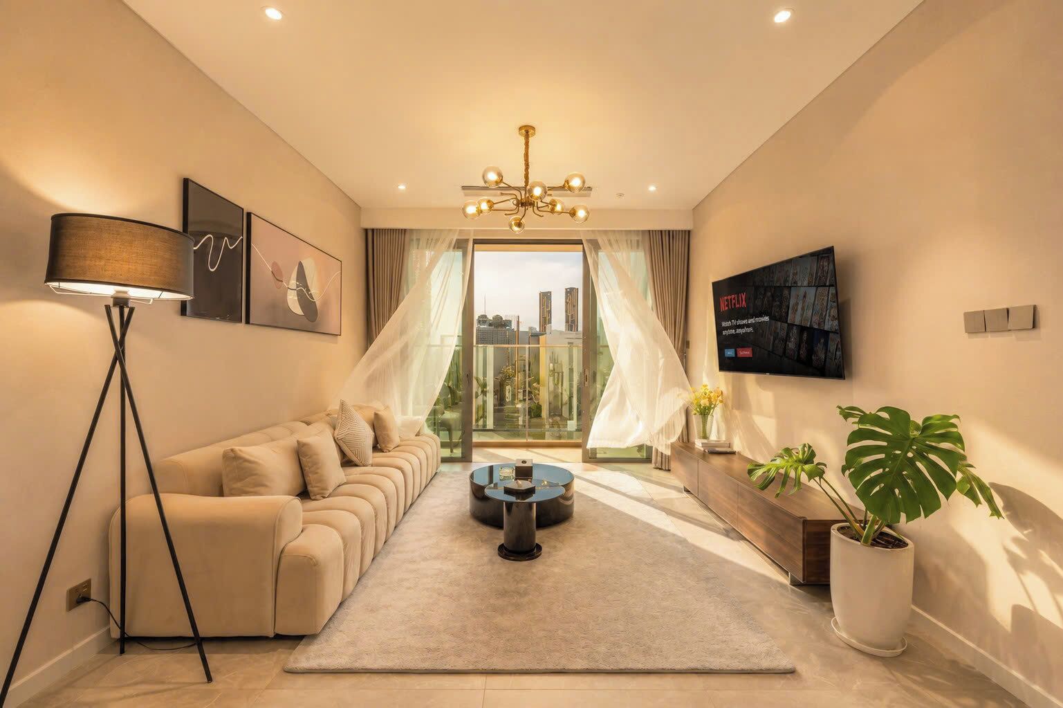 Una sala de estar moderna con un sofá, una mesa de centro, una lámpara de pie y un televisor montado en la pared.