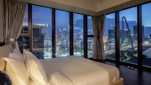Un dormitorio amplio con vistas a la ciudad, una cama y cortinas.