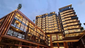 A modern hotel with multiple floors, large glass windows, and a well-lit entrance area.
