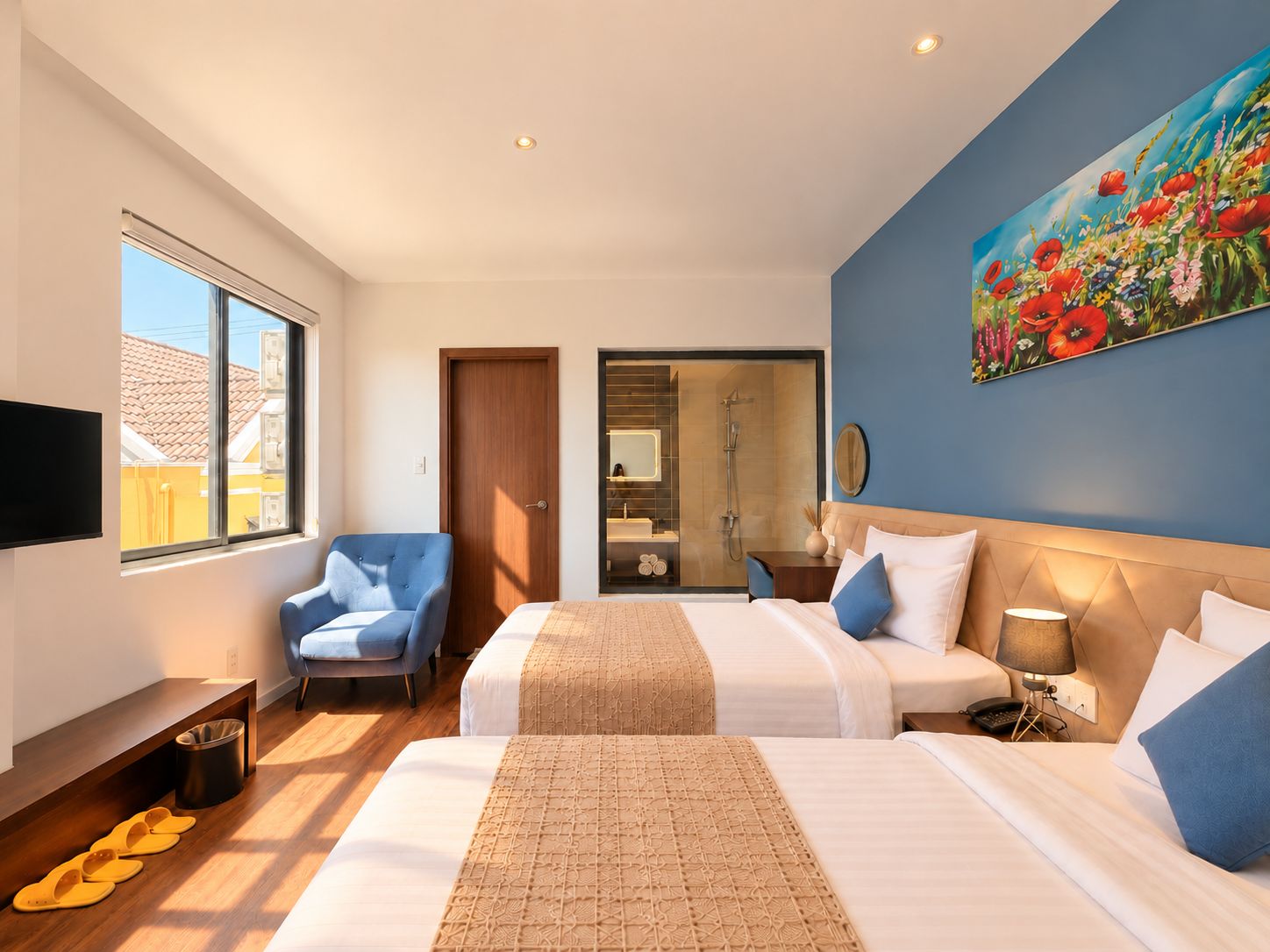 Habitación de hotel con dos camas, ducha, televisor y un cuadro en la pared.