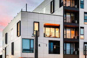 Um edifício moderno, de vários andares, com varandas, janelas amplas e fachada plana.