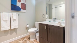 A modern bathroom with a toilet, sink, and dark wooden cabinets.