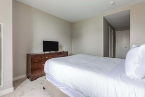Ein Schlafzimmer mit einem Bett, einer Kommode und einem Fernseher auf einem Schrank.
