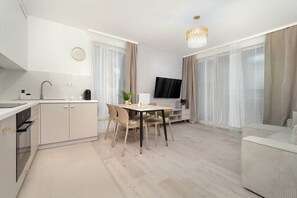 Relax in this spacious living area with a dining table, kitchen, and comfortable seating area.
