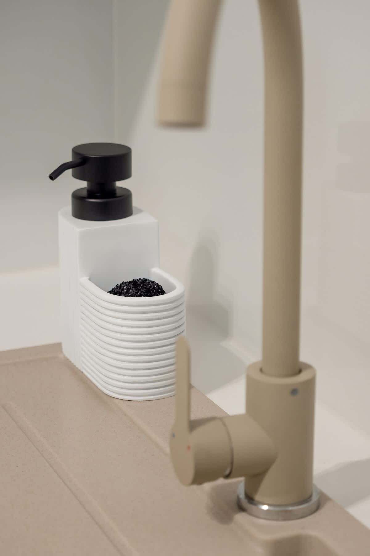 Un lavabo de salle de bain doté d’un robinet moderne et d’un distributeur de savon.