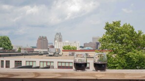 Two glasses of red wine on a wooden ledge with a city skyline in the background. - Jennifer's Penthouse 2 Floors - Amazing City View! (Providence)