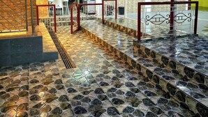 Een gebouw met een betegelde deuropening, metalen hekwerk en een bakstenen muur.