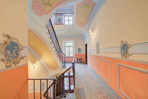A grand staircase with ornate railings and a high ceiling with decorative moldings. - Sunny Penthouse (Oulx)