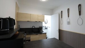 Une cuisine moderne avec des meubles en bois, un plan de travail noir et une fenêtre.
