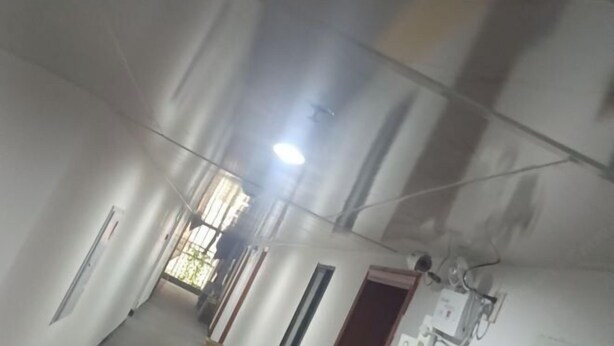 A room with a high ceiling, exposed ductwork, and a visible light fixture. - Shuangyong Hotel (Changsha)
