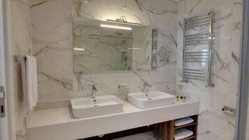 Un baño moderno con dos lavamanos, un espejo grande y un perchero para toallas.