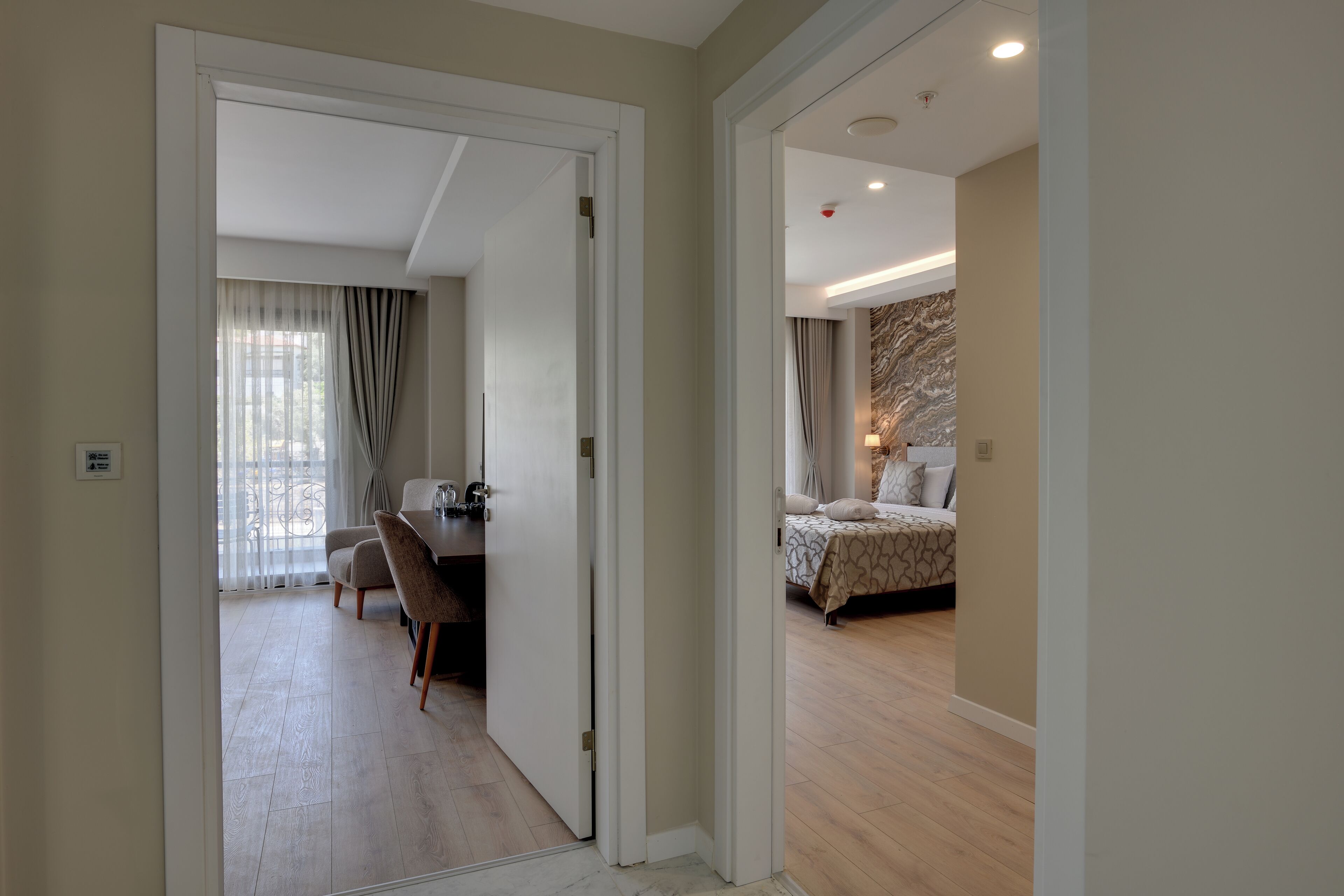 A hotel room with a bed, a desk, and a chair.