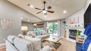 A living room with a ceiling fan, a fireplace, and a sofa set. - Pensacola Home w/ Fire Pit, 7 Mi to Beaches! (Pensacola)
