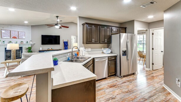 A modern kitchen with a central island, stainless steel appliances, and a ceiling fan. - Pensacola Home w/ Fire Pit, 7 Mi to Beaches! (Pensacola)